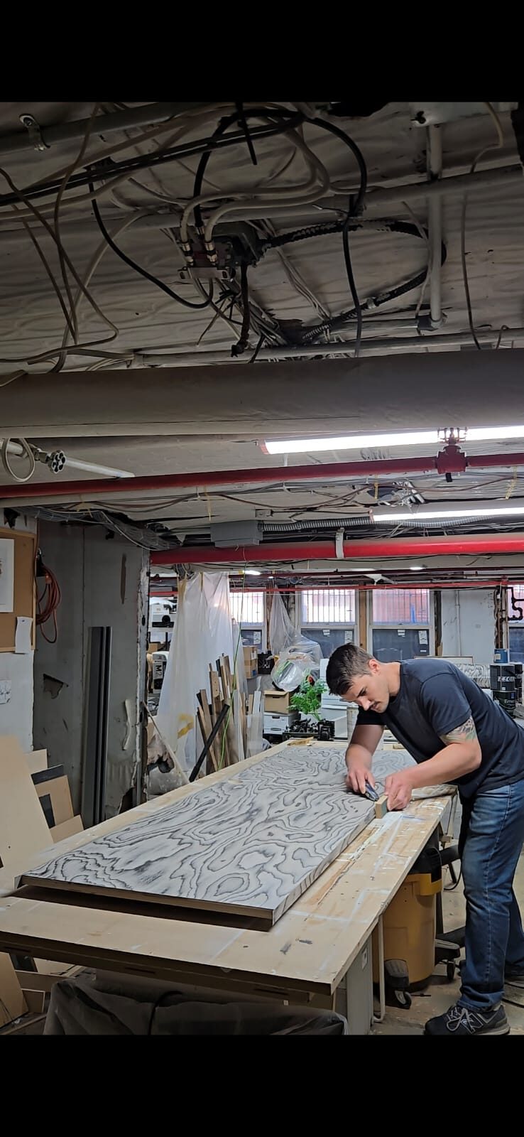 Greg Hyson hand-finishing a wood panel in the workshop